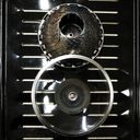 A saucepan lid and a steamer on an oven tray forming an eight.