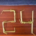 Twenty four spelt with rectilinear digits formed with yellow bendy drinking straws laid on a wooden surface.