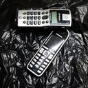 Two cordless telephone handsets arranged to form a seven.